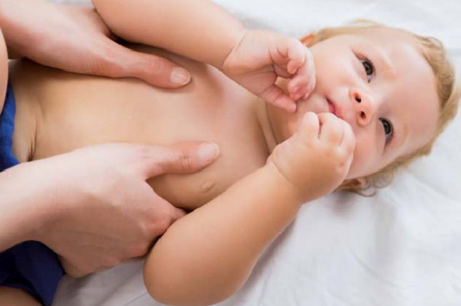 Thực hiện các động tác vuốt nhẹ song song từ vai trái và phải về phía ngực của trẻ