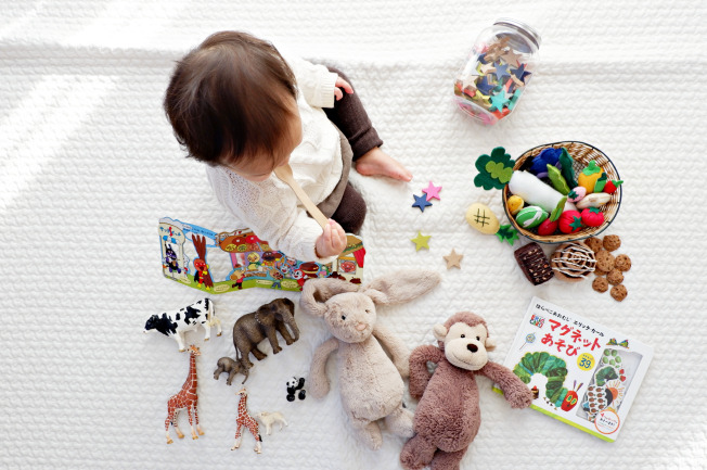 Bé 6 tháng tuổi với hoặc nhặt các đồ vật nhỏ bằng cách dùng tay đẩy chúng về phía mình