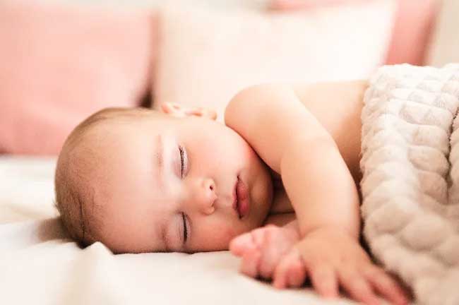 Bé ngủ không ngon giấc, hay giật mình có thể do các nguyên nhân sinh lý như: Phản xạ tự nhiên, tâm lý không ổn định hoặc có tiếng động lớn xung quanh chỗ ngủ của bé.