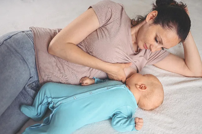 Mẹ có thể nằm cho bé bú khi mẹ đang mệt, mỏi tay hoặc mẹ vẫn còn đau sau sinh. 