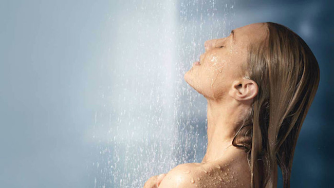 Mẹ để nước ấm từ vòi hoa sen chảy trên bầu ngực khi tắm