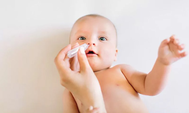 Vệ sinh mỗi bên mũi cho bé với 2 - 3 giọt nước muối sinh lý
