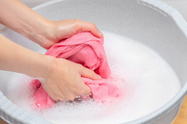 Sử dụng bàn chải mềm hoặc nước giặt chuyên dụng để loại bỏ vết bẩn cứng đầu trước khi cho vào máy giặt
