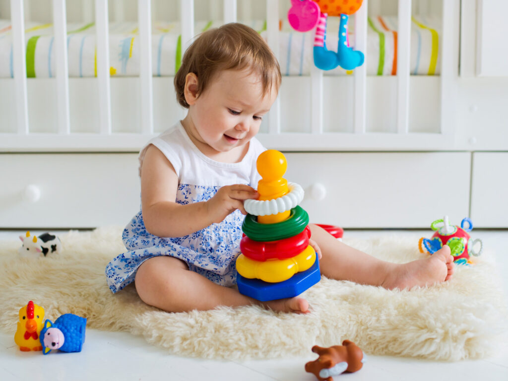 baby girl playing with educational toy nursery