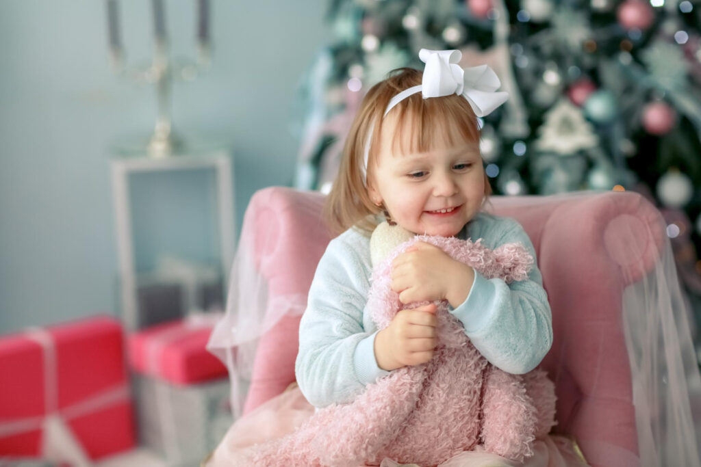 child close up background christmas tree hugs teddy bear
