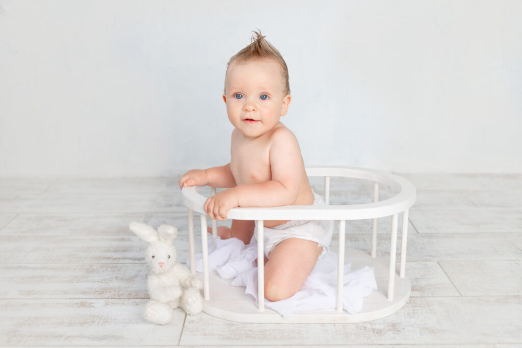 cute baby boy white background with hairstyle big blue eyes diapers white background with hairstyle sitting wooden basket